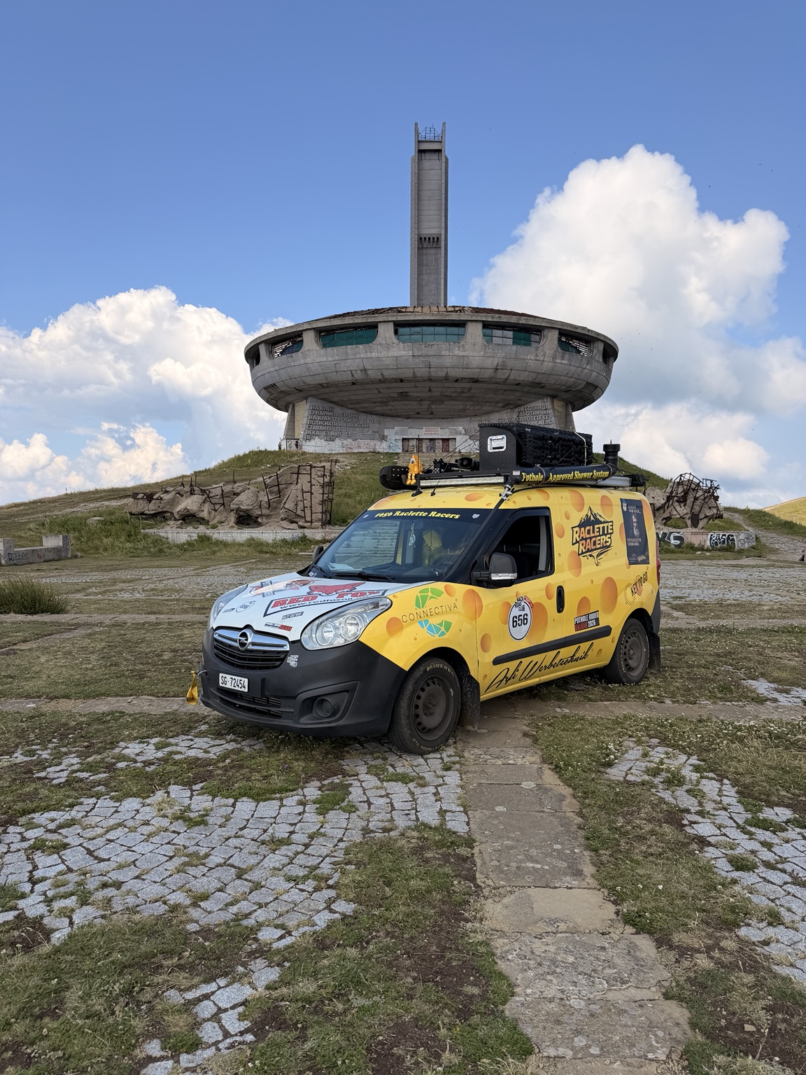 Das gelbe Käsemobil vor dem Buzludzha-Denkmal auf der Rally